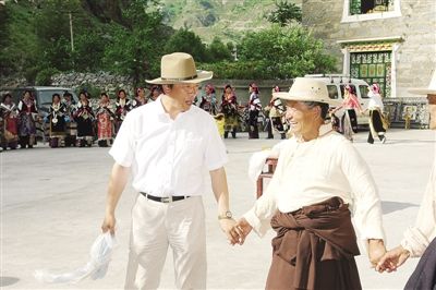 毕世祥(左)在丹巴县八底乡文化站与村民跳“锅庄”舞。 资料照片